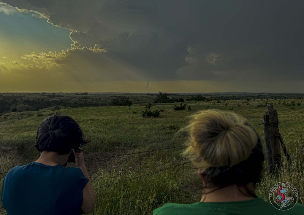 A couple of women watch a tornado develop from a low-precipitation supercell.
